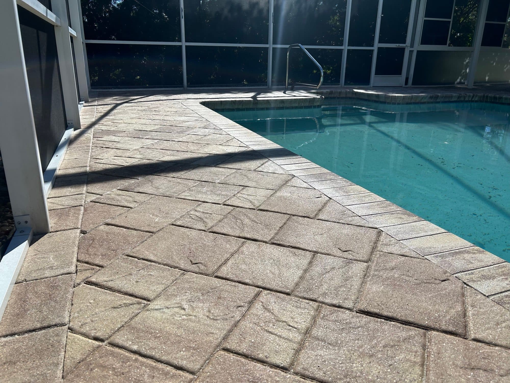 Sealed screened pool deck pavers in Cocoa Beach, FL — paver sealing and restoration by Atlantic Exteriors